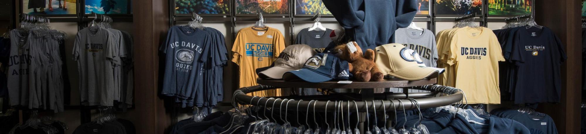 Interior of the UC Davis bookstore with branded hats and shirts visible