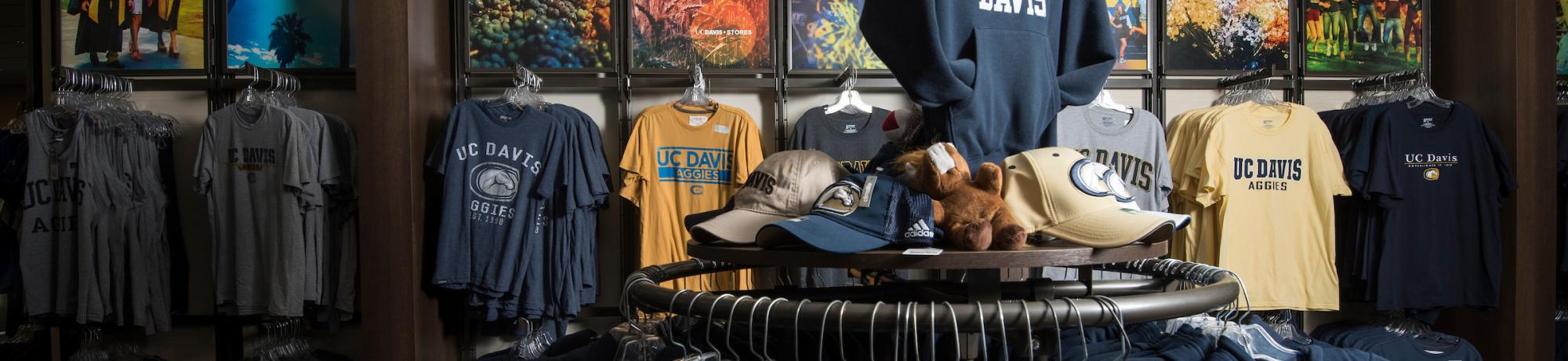 Interior of the UC Davis bookstore with branded hats and shirts visible
