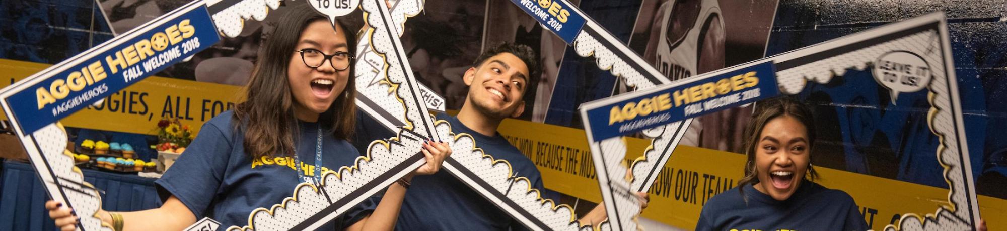 Students pose with social media signs at the Aggie heroes event