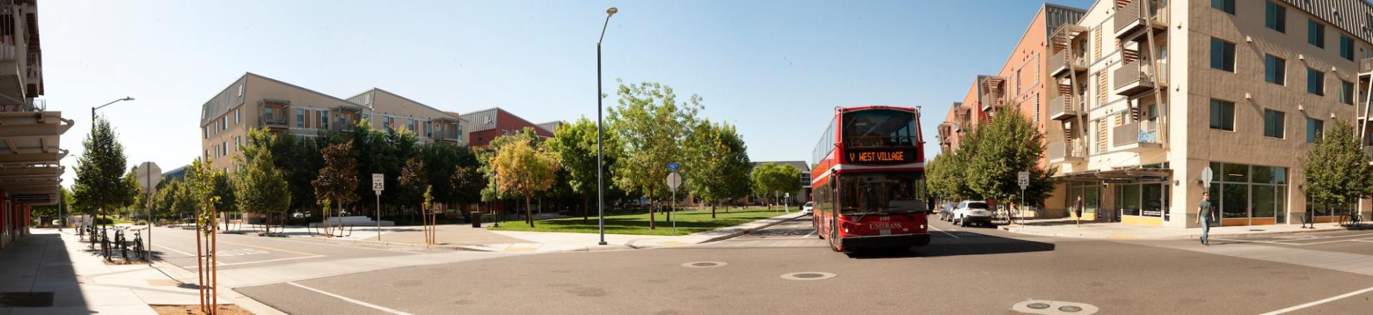 panorama of Unitrans double decker bus driving through West Village Davis CA