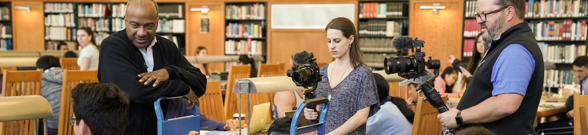 Two video producers filming a conversation in a library